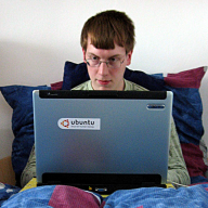 Pitel v posteli s laptopem